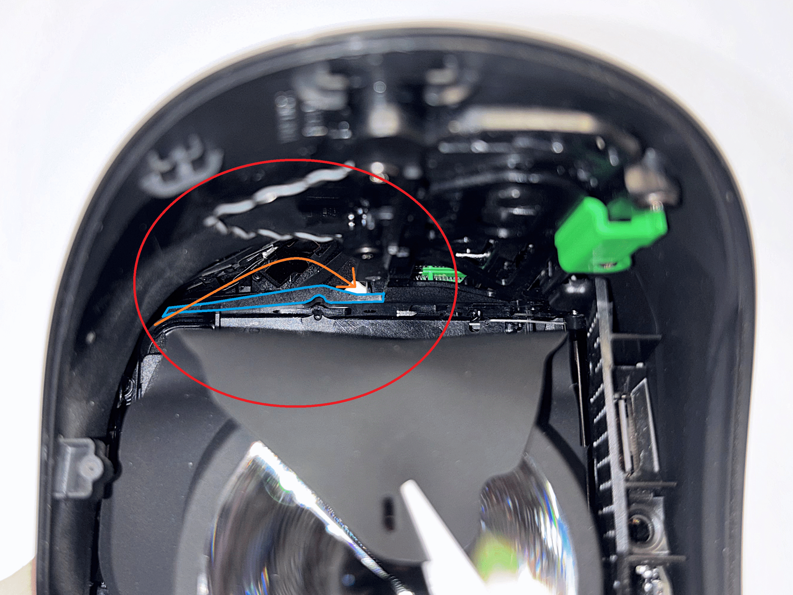 Pavyzdinis paveikslėlis su mėlynai pažymėta plastikine detalimi ir oranžine rodykle kabelio vedimui